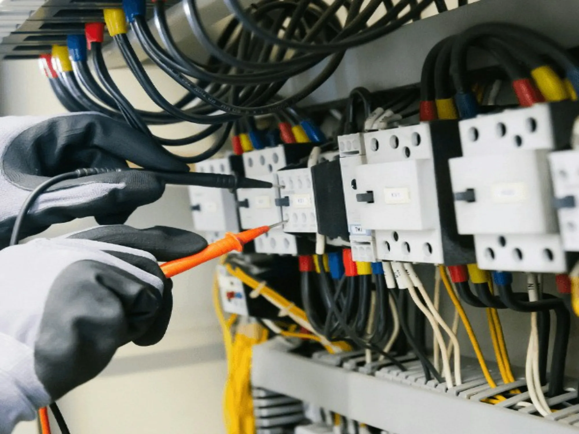 Electrician testing a breaker panel with a voltage probe