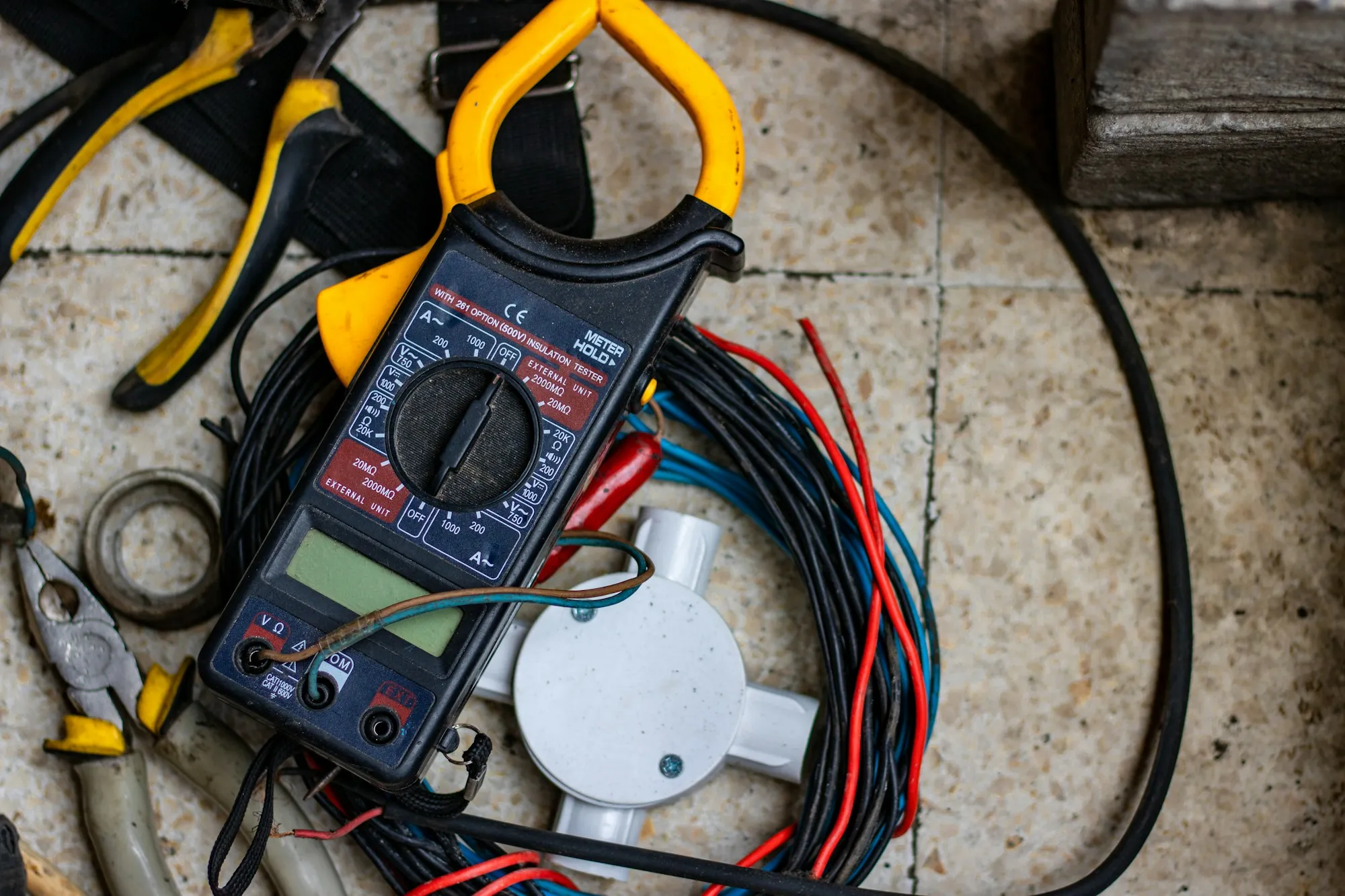 Clamp meter and test leads on a bundle of electrical wire